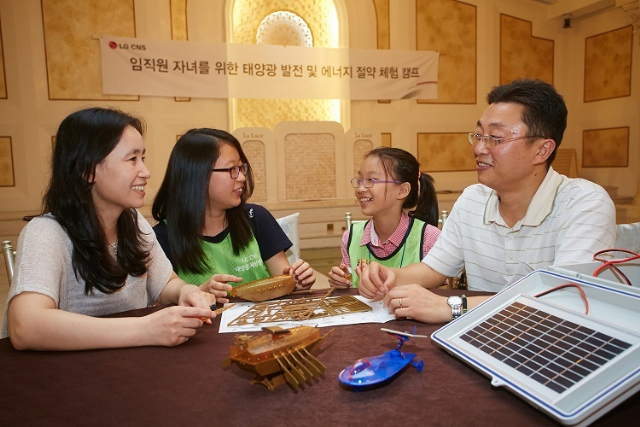 14일 LG CNS 임직원 자녀를 대상으로 개최된 ‘태양아! 어디가?’ 행사에 참가한 전략사업팀 이종남 차장 가족들이 태양광 구동 거북선을 조립하여 즐거워하고 있다.